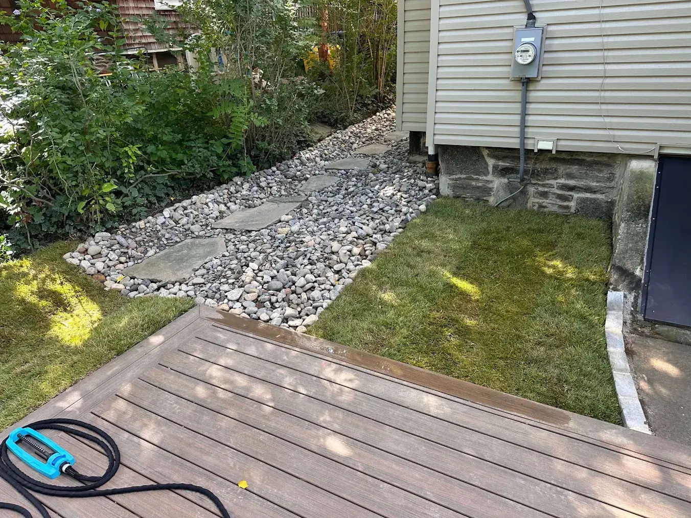 Finished stone drainage path and lawn.